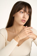 Model with hands together wearing an open heart tennis bracelet