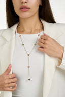 Model in a white blazer wearing a gold tone lariat necklace with colorful heart crystals