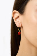 Red enamel heart charm hoop earrings in gold tone worn on model ear - AURA Jewelry