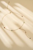 Colorful heart lariat necklace on a beige background