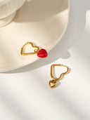 Heart hoop earrings with dangling heart charm in gold and red enamel on white background - AURA Jewelry