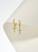 Gold tone pave crystal cross huggie hoop earrings with sparkling CZ cross charm on white background - AURA Jewelry